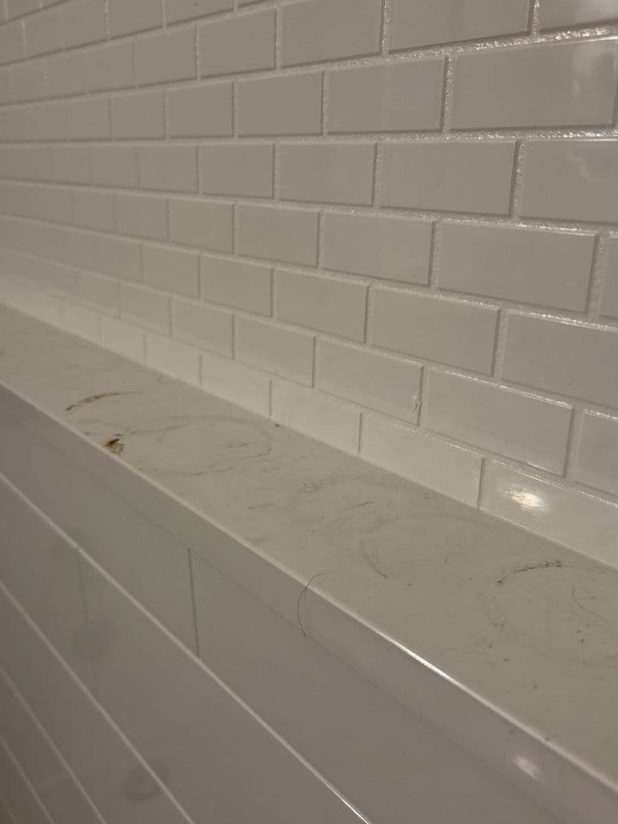 Shower ledge and tile before cleaning by Red Deer House Cleaning