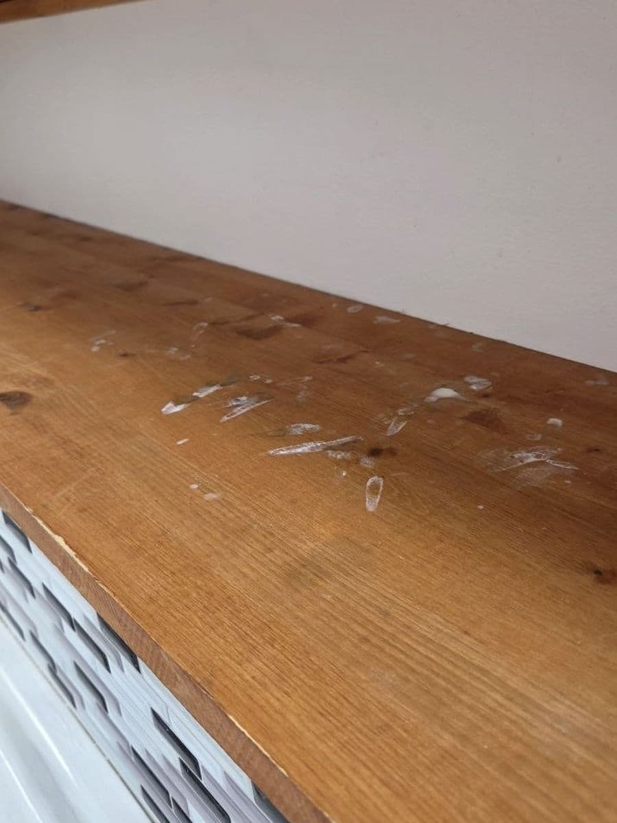 Wood counter with dried splashes before cleaning by Red Deer House Cleaning
